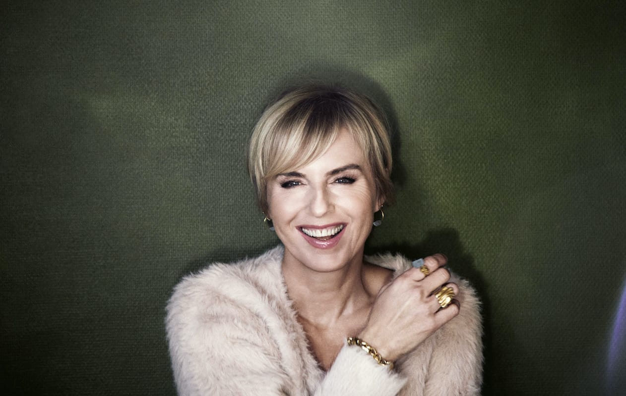 Portrett av Silje Nergaard som smiler mot kamera med en arm på motsatt skulder.